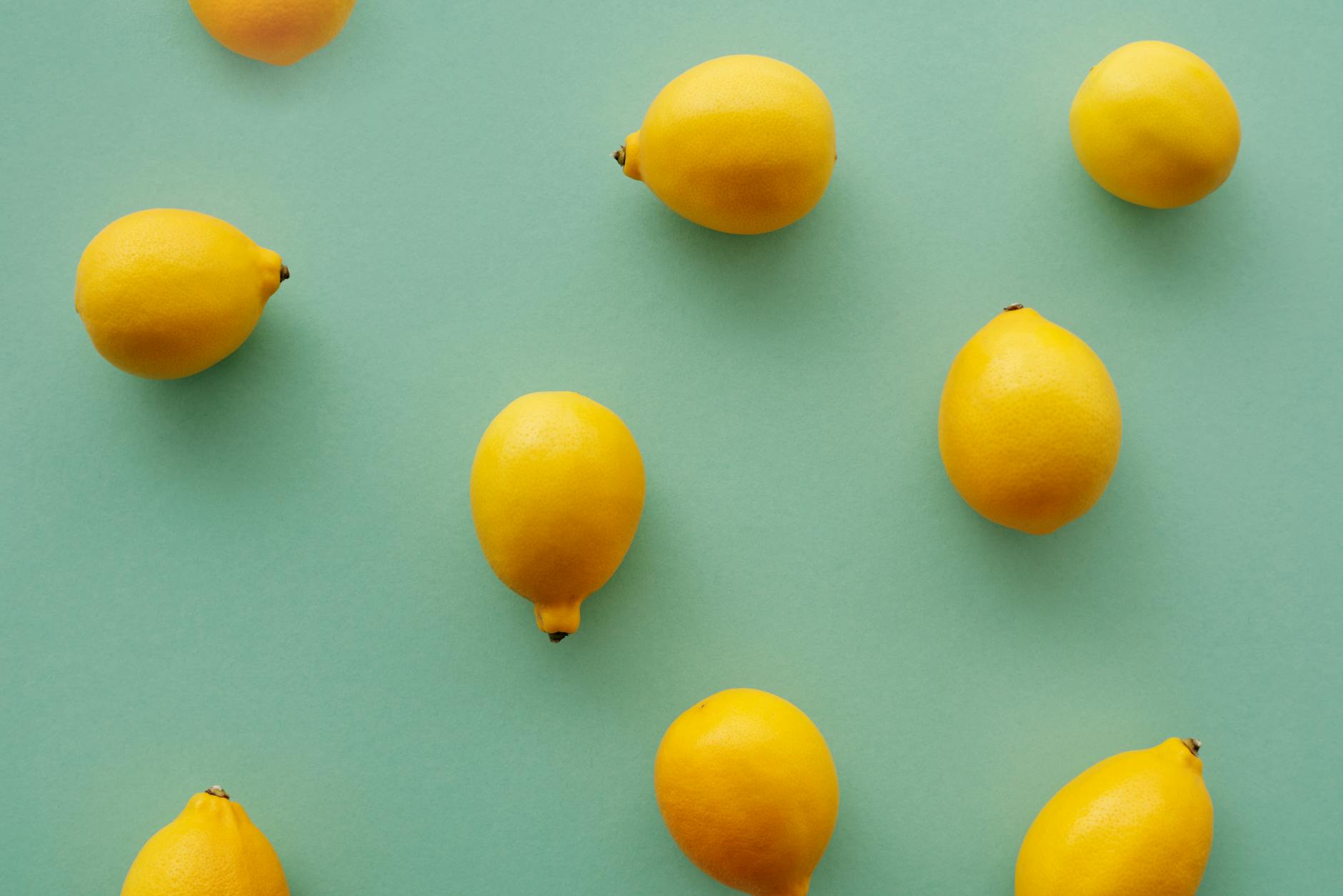 Bright yellow lemons arranged on a pastel background, symbolizing the refreshing approach to reclaiming pleasure