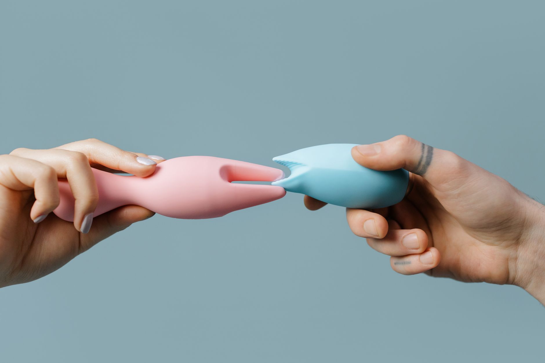 Intimate close-up of hands gently holding a sleek vibrator, representing tender reconnection with pleasure