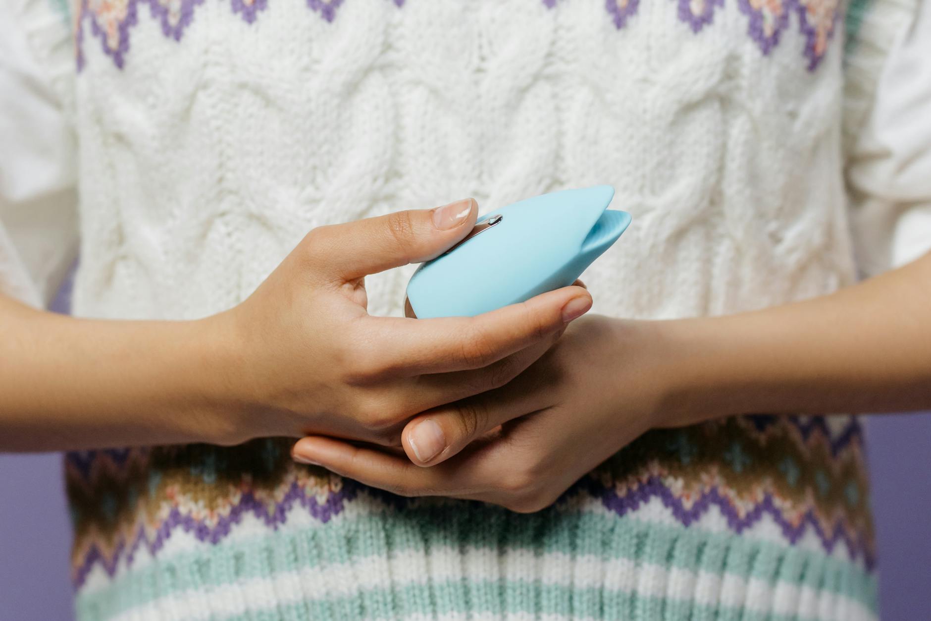 Close-up of hands holding a personal massager, symbolizing intimate communication and connection between partners