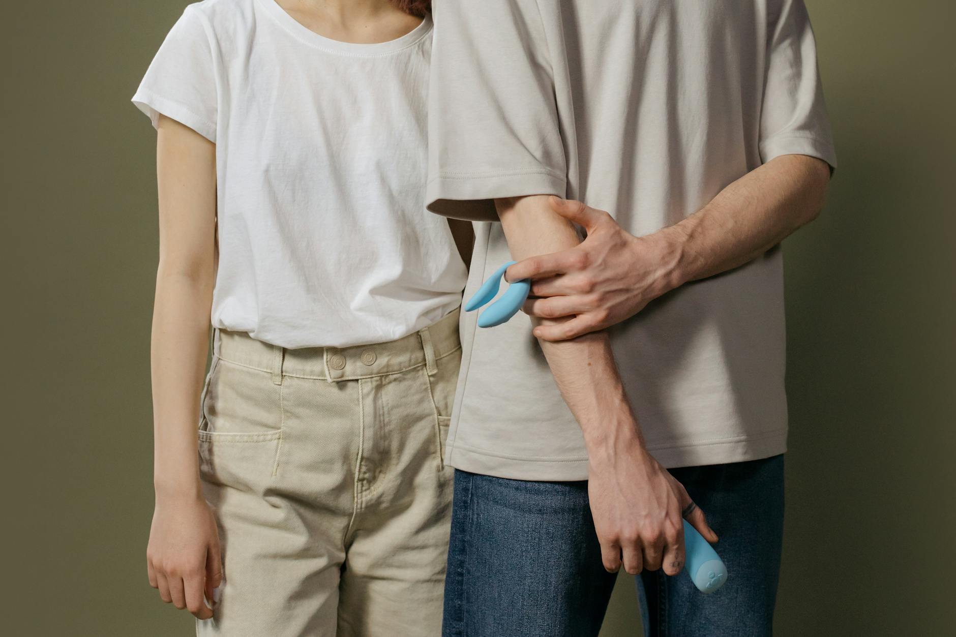 Hand holding a lemon against a soft pink background, symbolizing sensitivity and refreshed sensation