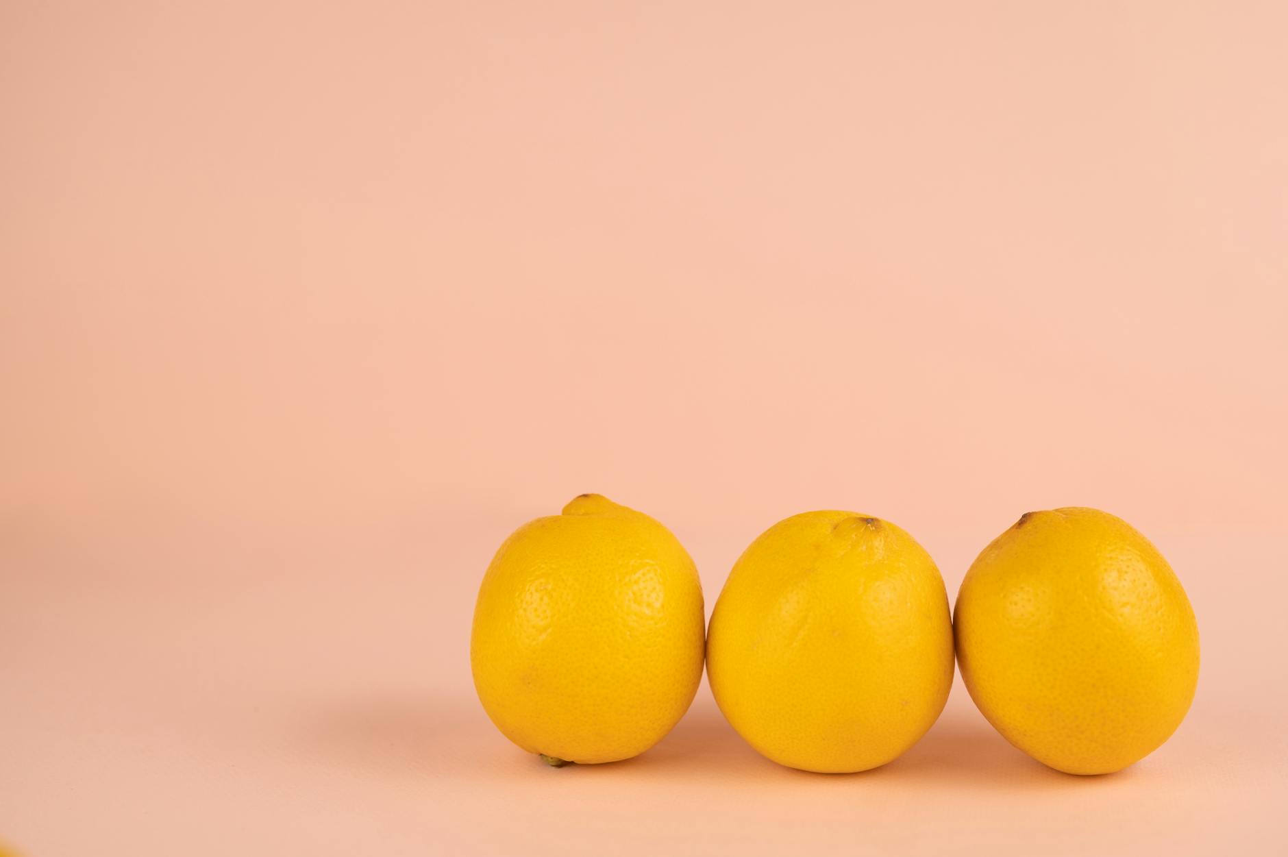 Fresh lemons arranged on a soft pastel background, symbolizing citrus vibrancy and renewal